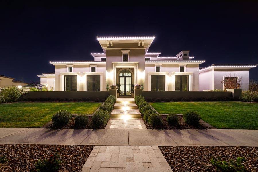 Warm white permanent lighting outlining a large single-story home